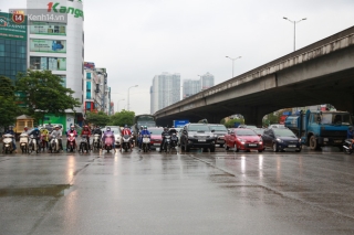 Ảnh: Ngày đầu tiên sau lệnh cách ly xã hội đường phố Hà Nội đông đúc kéo dài, người dân chật vật đi làm dưới mưa rét - Ảnh 1.