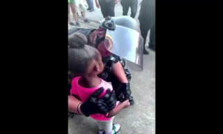 Cảnh sát da trắng ôm bé gái da màu giữa biểu tình - Ảnh 1.