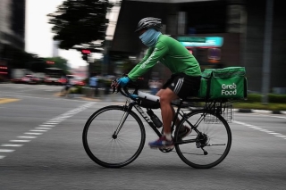 Một tài xế GrabFood giao hàng bằng xe đạp ở Singapore. (Ảnh: ST)