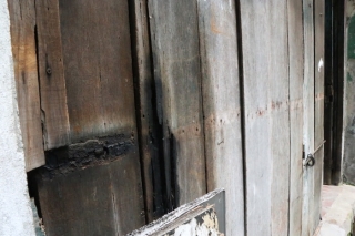 Tấm cửa làm bằng gỗ đã mục, hư hỏng nhiều chỗ.