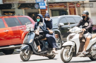 Nhiệt độ ngoài đường tại Hà Nội lên tới 50 độ C, người dân trùm khăn áo kín mít di chuyển trên phố - Ảnh 1.