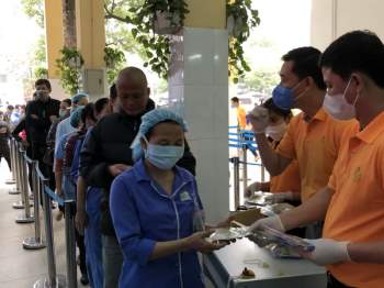 Nhân viên TV.Pharm phát khẩu trang tại Bệnh viện Việt Đức, Hà Nội.