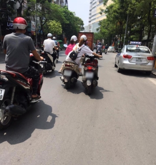 Pha dắt xe cồng kềnh của 2 cô gái trên đường phố Hà Nội khiến nhiều người thót tim: Ai lại mang lý thuyết dắt xe đạp để dắt xe máy thế này - Ảnh 1.