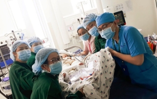 2 bé song sinh Diệu Nhi - Trúc Nhi đã bớt sốt, các bác sĩ tiến hành chuyển bé qua nệm chống loét, nhiễm trùng - Ảnh 1.