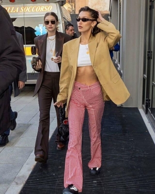 Diện mạo gợi cảm của chân dài Bella Hadid trong kiểu áo croptop, áo blazer màu da bò mix cùng quần caro với phần cạp so le