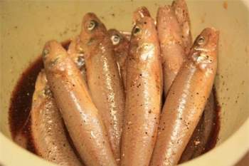 Rắc tiêu sọ và tiêu xay vào nồi cá rồi đổ hỗn hợp gia vị vào sao cho sâm sấp mặt cá, để 20 phút cho cá thấm gia vị.