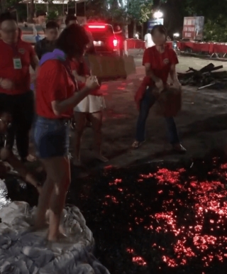 Cộng đồng mạng xôn xao với cảnh tượng đám đông hò reo giục cô gái đi trên đống than đỏ rực, kết quả khiến ai cũng bất ngờ - Ảnh 1.