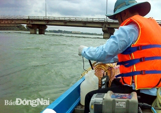 Cán bộ môi trường lấy mẫu nước trên sông Đồng Nai thực hiện quan trắc 