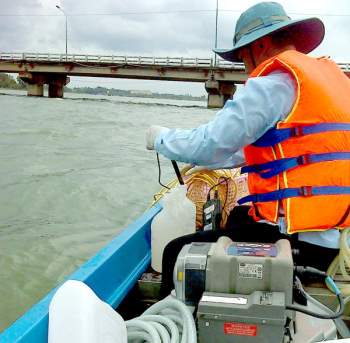 Cán bộ môi trường lấy mẫu nước tại sông Đồng Nai để thực hiện quan trắc. Ảnh: Ban Mai
