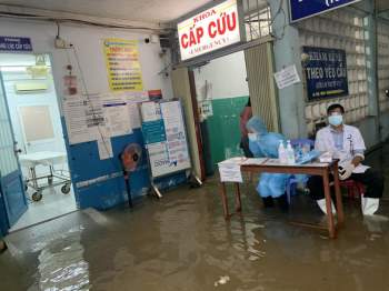 Mưa 3 tiếng, bác sĩ bệnh viện ở Hóc Môn xắn quần lội nước khám bệnh - Ảnh 2.