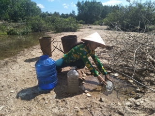 Người dân Vân Canh thiếu nước sinh hoạt phải ra suối múc từng can nước về dùng.