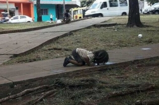 Bức ảnh bé gái quỳ rạp xuống đất, uống nước từ vũng nước bẩn trên đường khiến cả thế giới xót xa và câu chuyện ít ai biết - Ảnh 1.