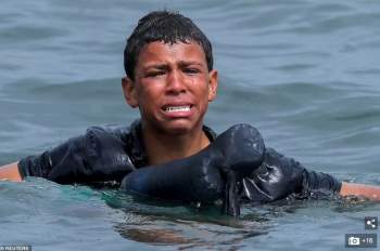 Khoảnh khắc cậu bé di cư bật khóc giữa biển nước mênh mông, dùng chai nhựa để bơi đến miền đất hứa gây chấn động thế giới - Ảnh 1.