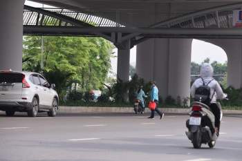Hà Nội: Bất chấp nguy hiểm, nhiều người đi bộ không dùng cầu vượt, chọn cách băng qua 12 làn xe để sang đường Phạm Văn Đồng - Ảnh 1.