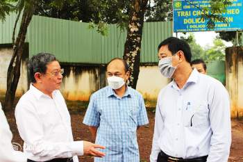 Phó chủ tịch UBND tỉnh Võ Văn Phi (phải) đi kiểm tra môi trường trang trại heo tại H.Vĩnh Cửu. Ảnh: H.Lộc
