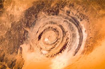 2. Con mắt Sahara, còn gọi là Cấu trúc Richat, là một hiện tượng đáng kinh ngạc nhìn từ Trạm vũ trụ quốc tế. Vòng xoáy rộng 30 dặm (48,2km) như mắt bò hay vỏ ốc sên, trước đây được cho là hình thành từ dung nham núi lửa. Tuy nhiên, sự tiến bộ trong khoa học địa chất đã hé lộ rằng nó là kết quả của sự xói mòn theo thời gian.